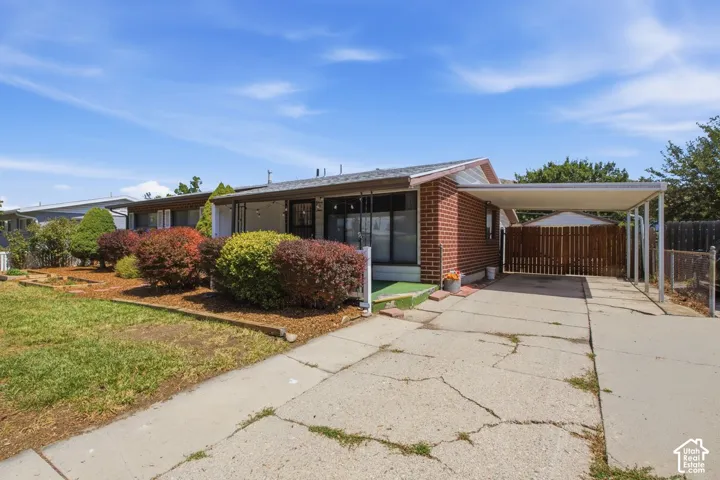 Brick exterior with a carport and front yard landscaping