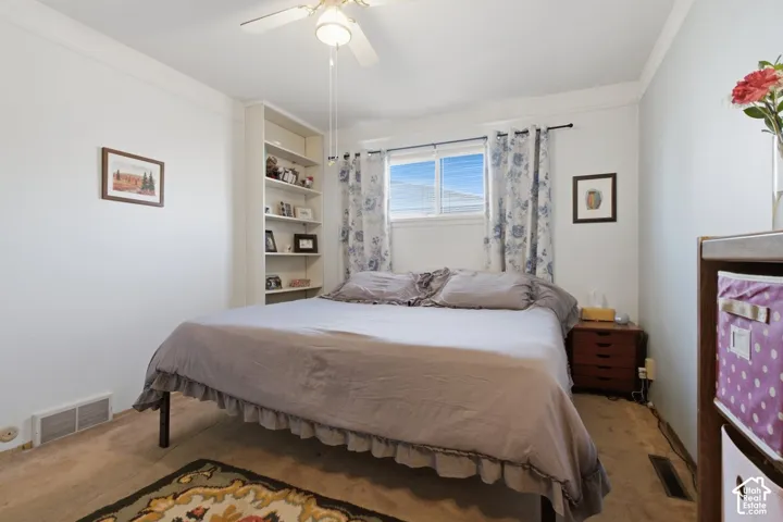Built-in shelving, ceiling fan with integrated lighting, and a window with blinds