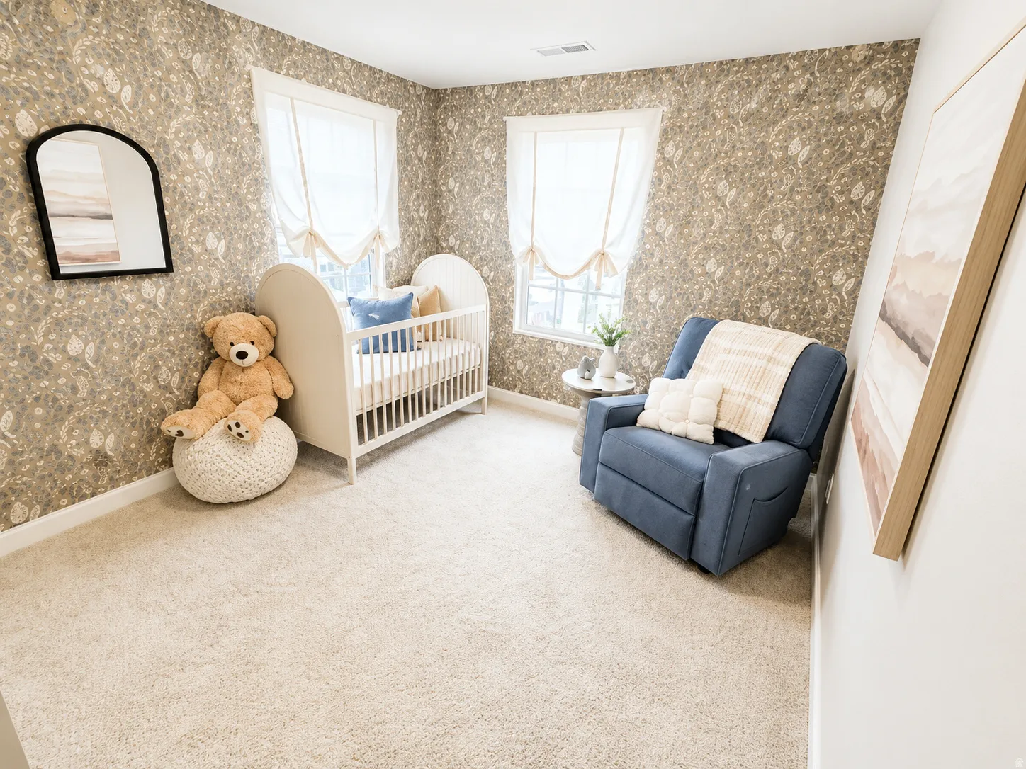 Textured wallpaper accentuates the walls, complemented by two windows with Roman shades