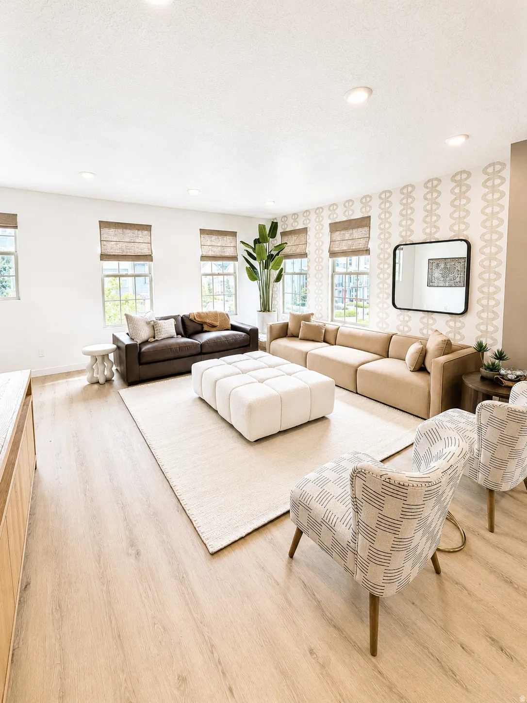 Recessed ceiling lighting, wood-finish flooring, multiple windows with natural woven shades, and an accent wall with a geometric pattern
