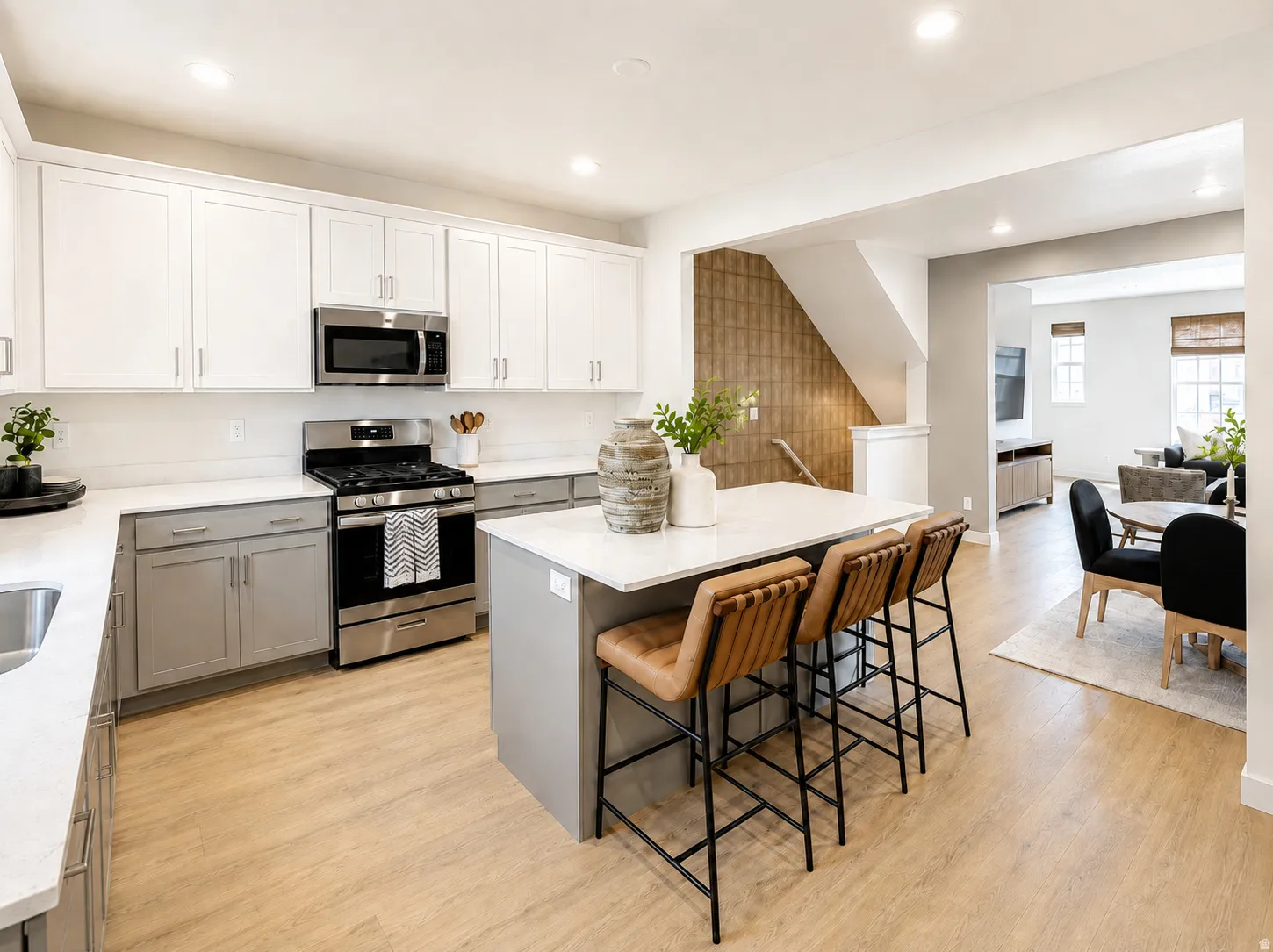 Kitchen featuring white upper cabinetry, gray lower cabinetry, and stainless steel appliances