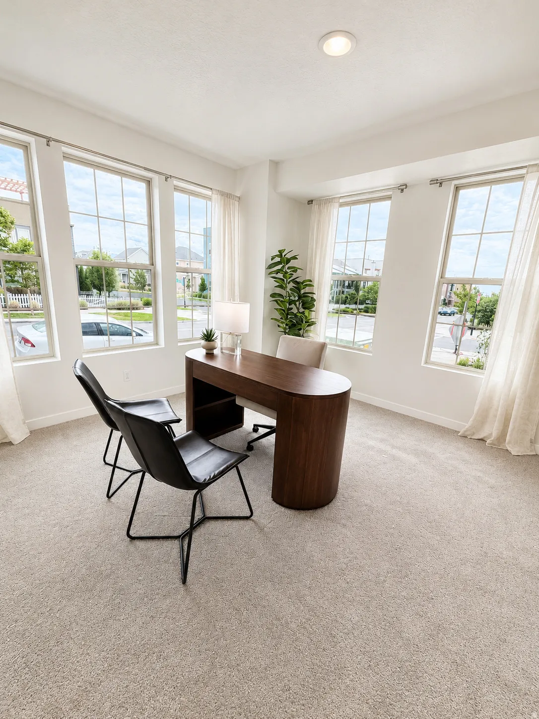Recessed lighting, multiple large windows, and neutral carpeting