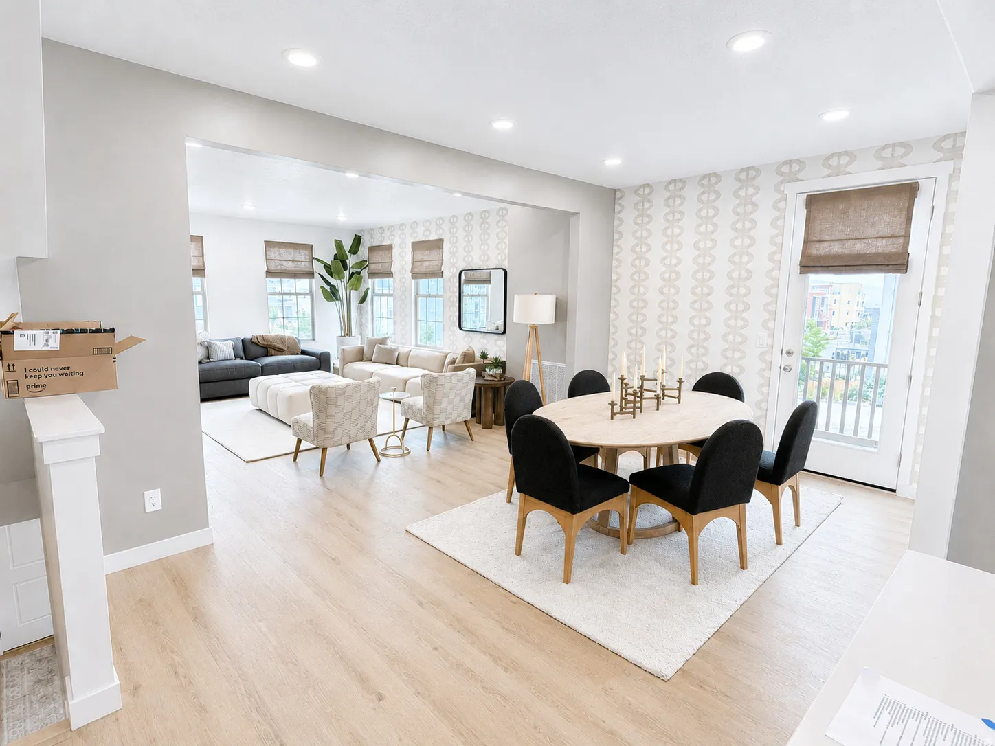 Recessed lighting illuminates the open-concept living space with light-toned wood-finish flooring