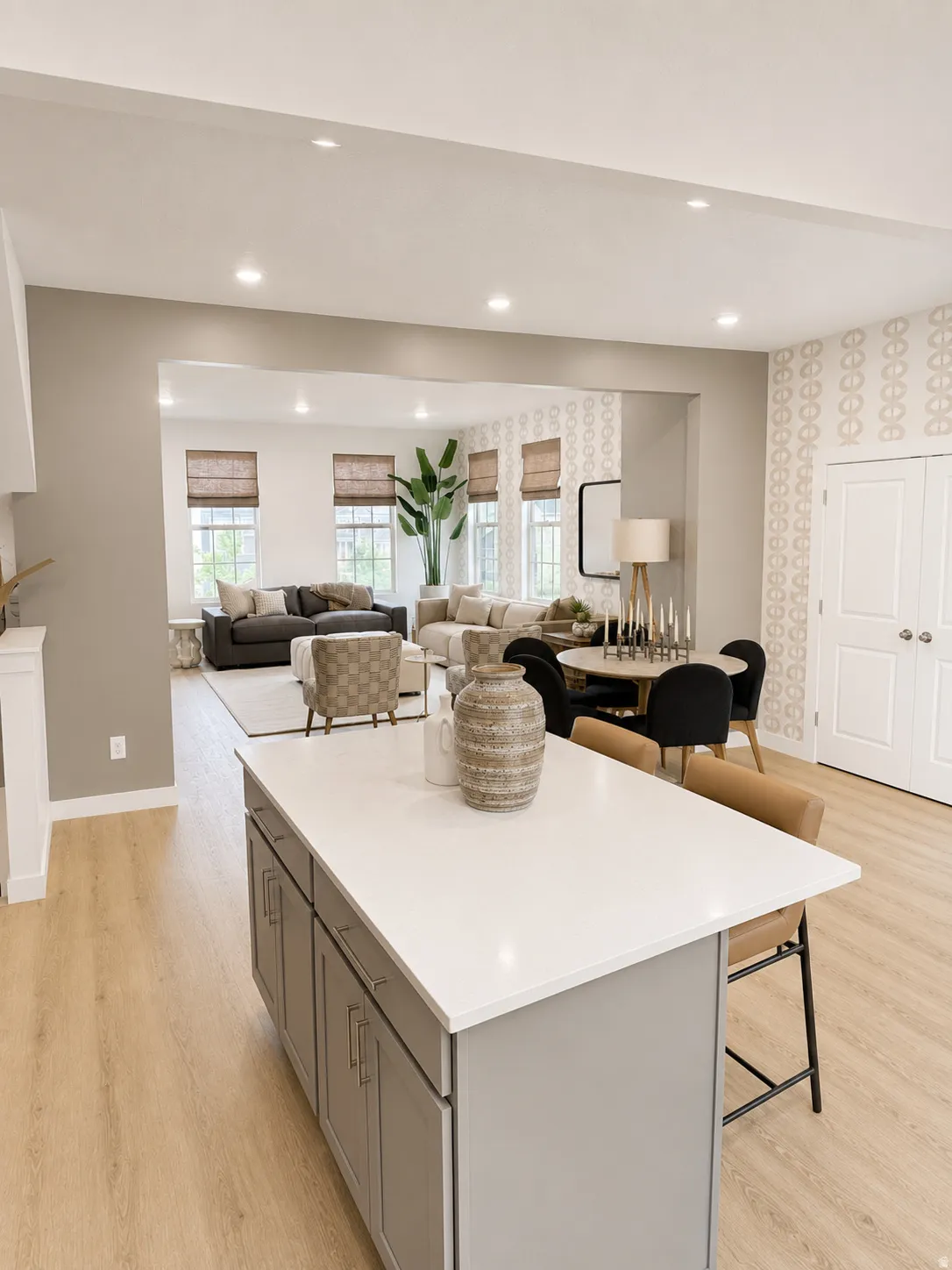 Open-concept living area with recessed lighting, wood-finish flooring, a kitchen island with a light-toned countertop, and a dining area