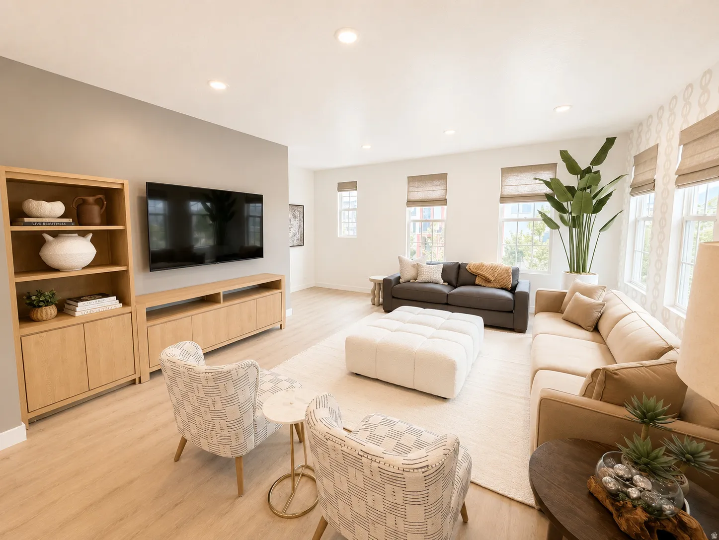 Recessed ceiling lighting illuminates the open-concept living area with wood-finish flooring