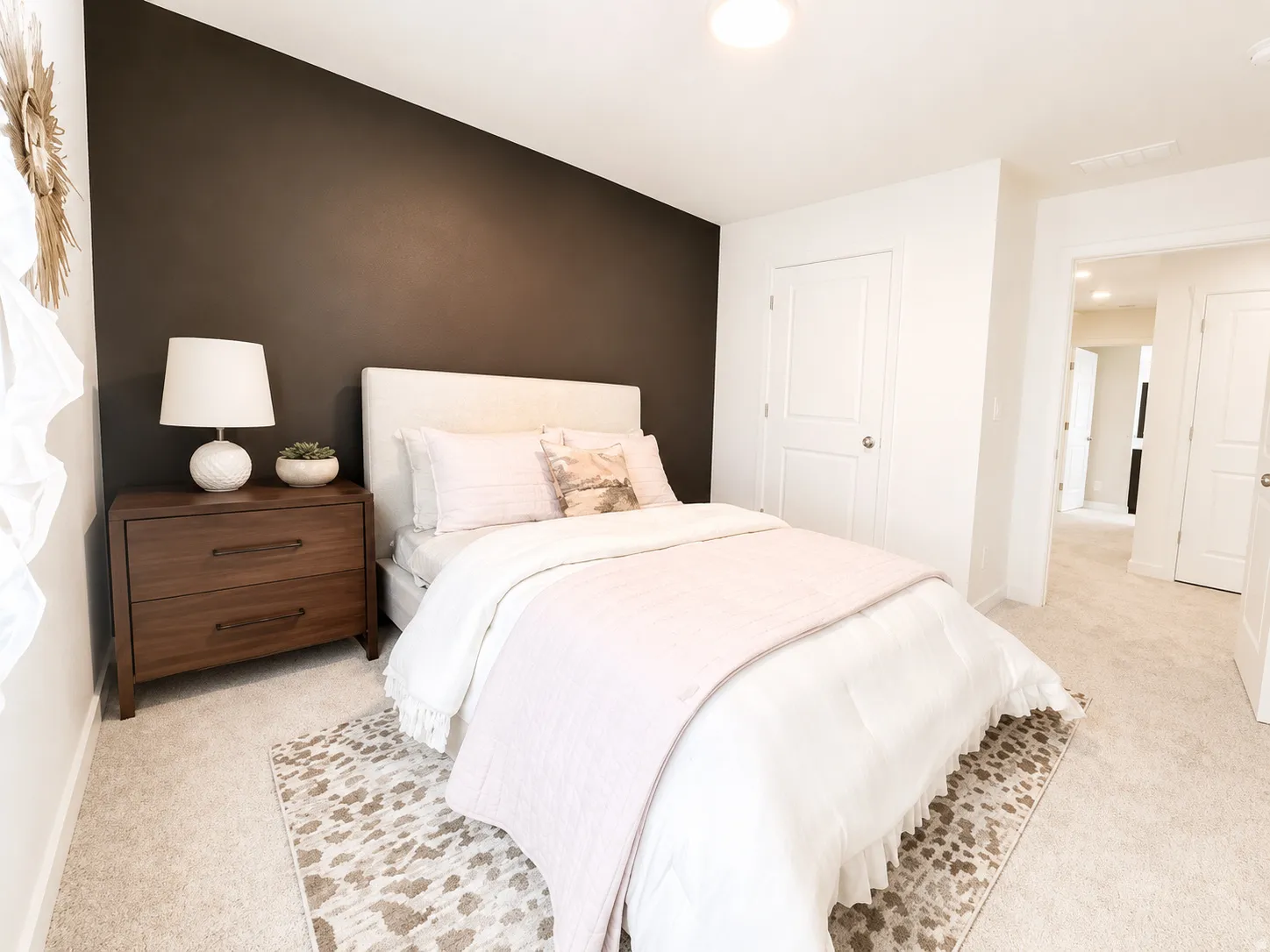 Plush carpet flooring, a built-in closet with white paneled doors, and a decorative accent wall