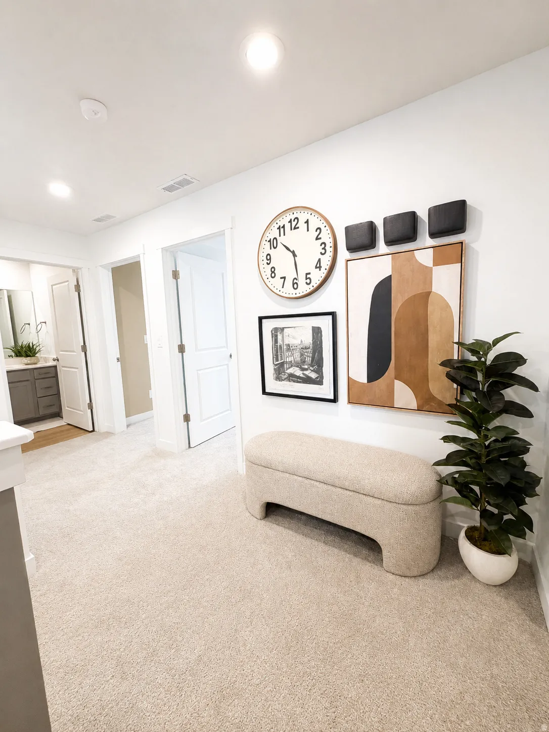 Recessed lighting, light-toned carpeting, and a white interior door