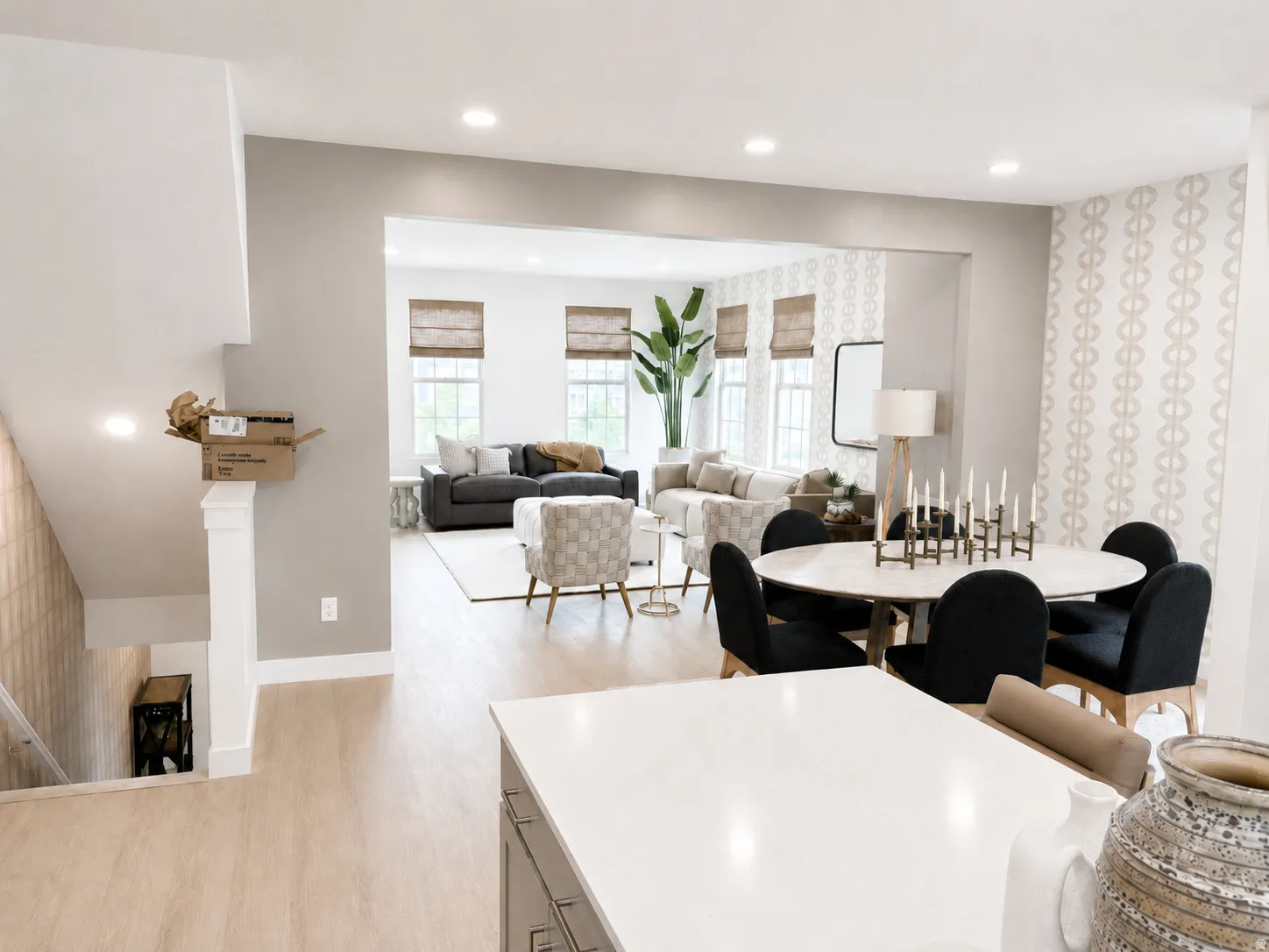 White countertops, light wood-finish flooring, recessed lighting, and an open concept layout