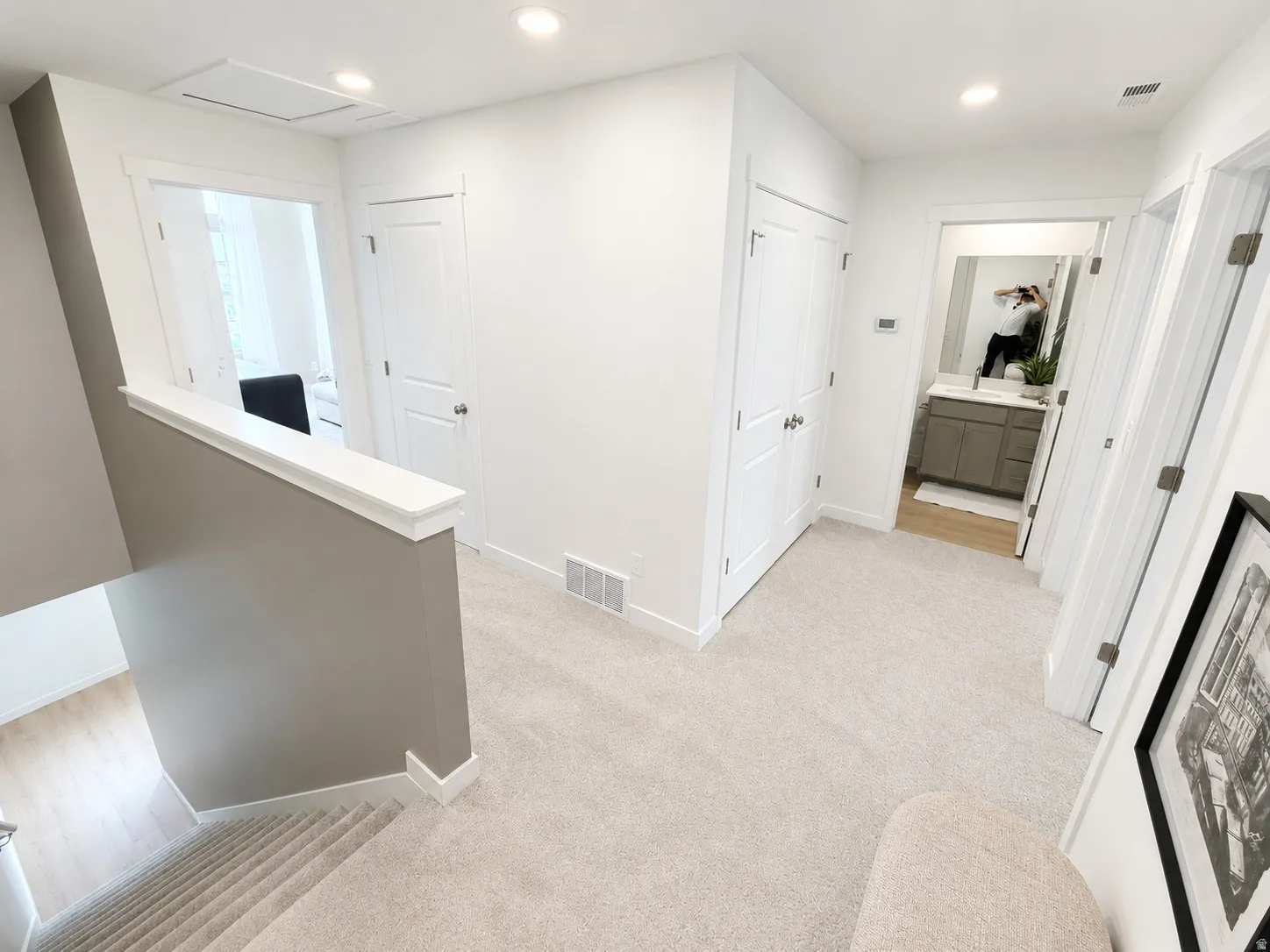 Light-toned carpeted flooring throughout the hallway