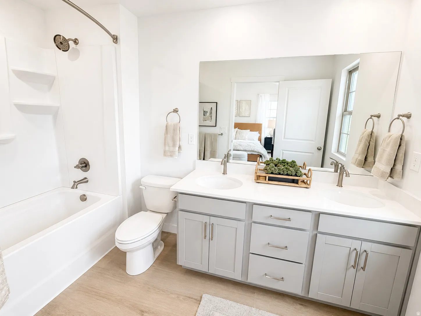 Dual sink vanity with light gray cabinetry, white countertops, and brushed nickel hardware