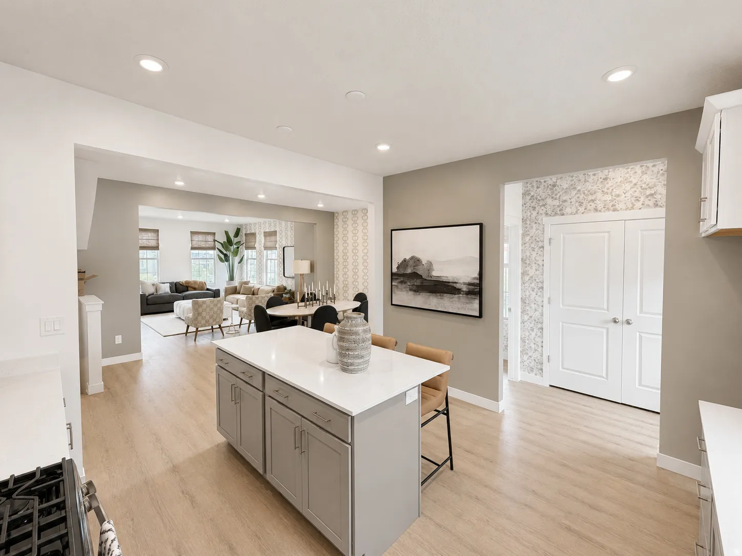 Kitchen island with a light-toned countertop, wood-finish flooring, recessed lighting, and white cabinetry