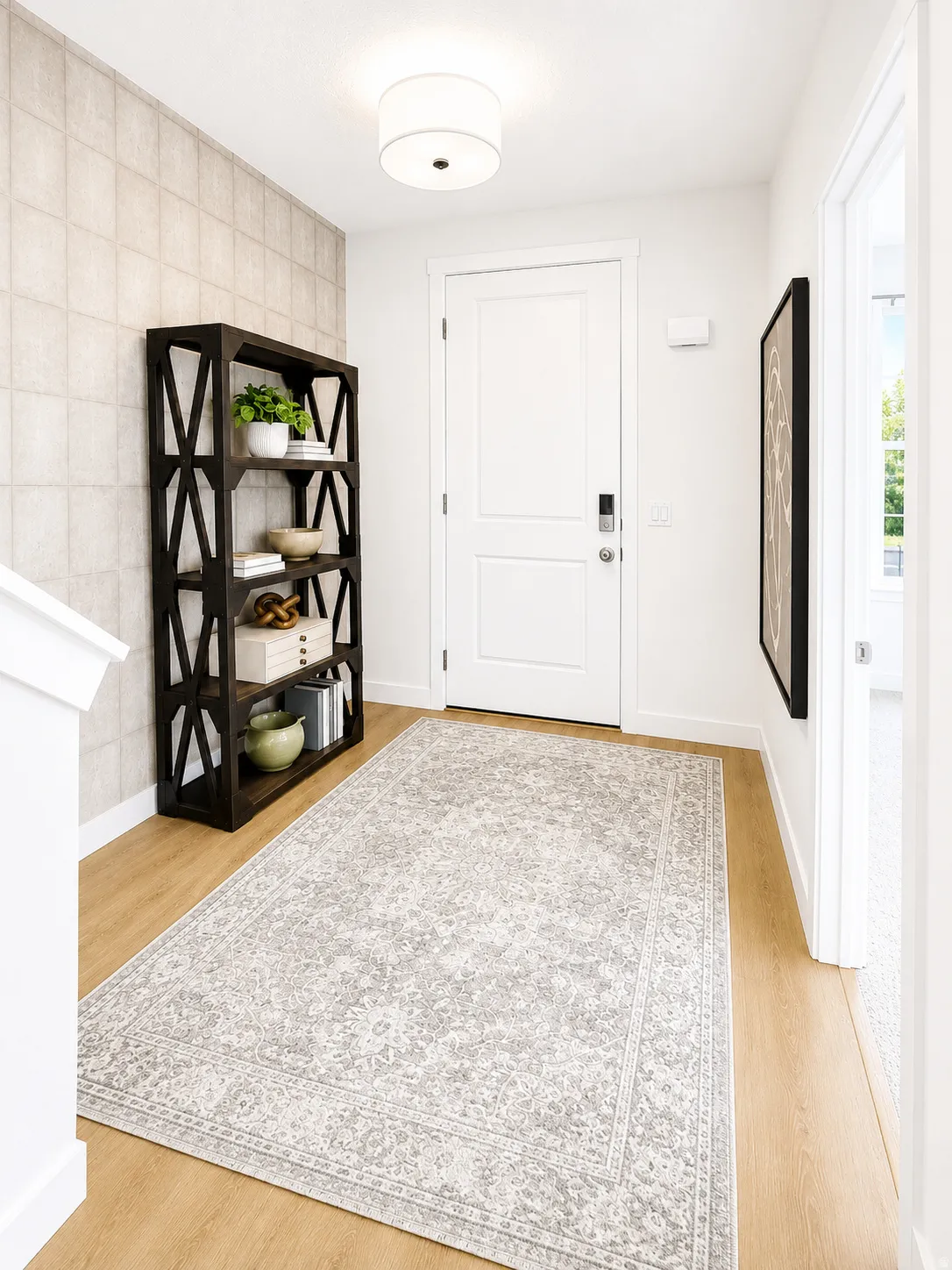 Recessed panel entry door with smart lock, wood-finish flooring, and a contemporary ceiling light fixture