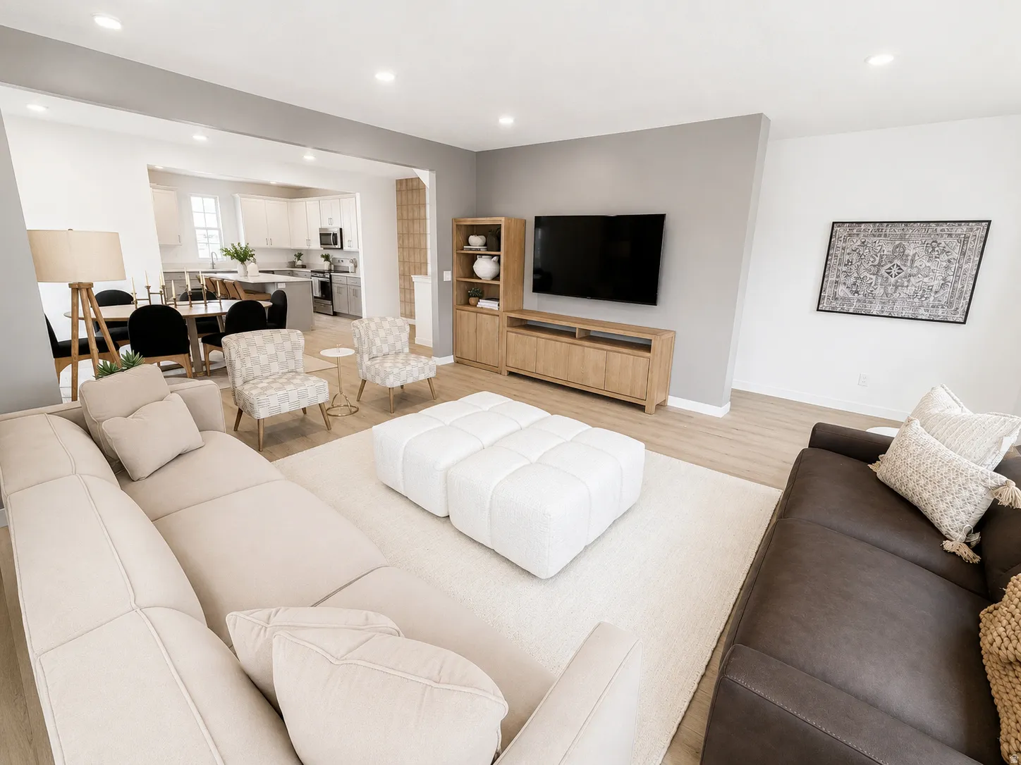 Open-concept living area with light wood-finish flooring, recessed lighting, and a neutral color palette