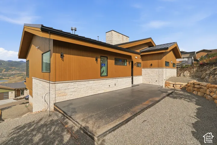 Contemporary exterior featuring wood-tone siding and a stacked stone facade
