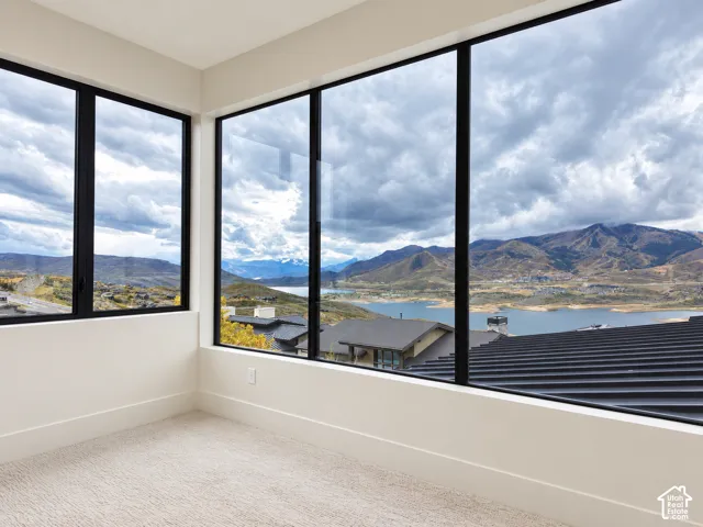 Expansive windows with black frames, carpet flooring, white walls, and white trim