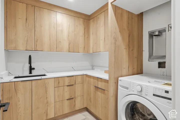 Wood-finish cabinetry, white countertops, built-in sink with a matte black faucet, and recessed lighting