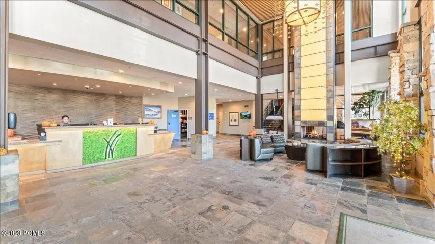 Spacious lobby featuring stone flooring, a large stone fireplace, and a multi-level architectural design with high ceilings