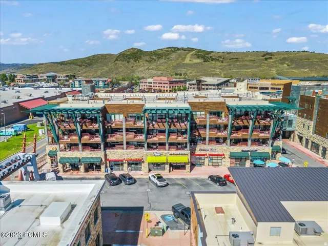 Multi-story building featuring lower-level commercial spaces with awnings and upper-level residences with private balconies
