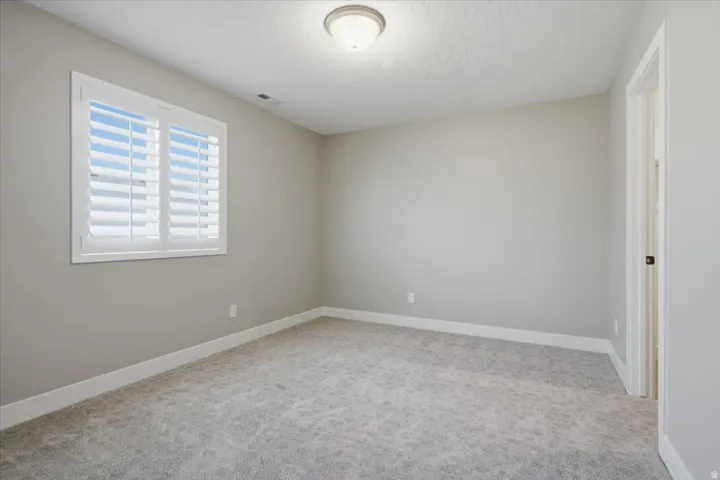 Neutral-toned walls complement the gray carpet
