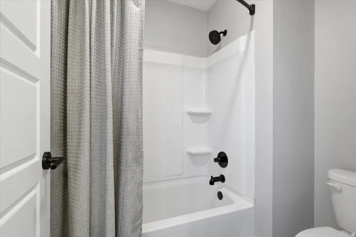 White tub and shower combination with black fixtures