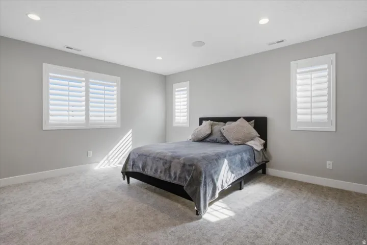 Recessed ceiling lights illuminate gray walls and plush gray carpeting