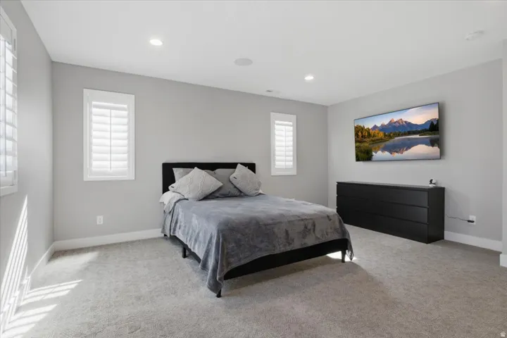 Carpeted room with recessed lighting and a ceiling-mounted speaker