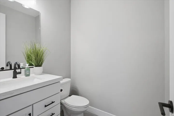 White vanity with integrated sink, rectangular mirror, and matte black faucet
