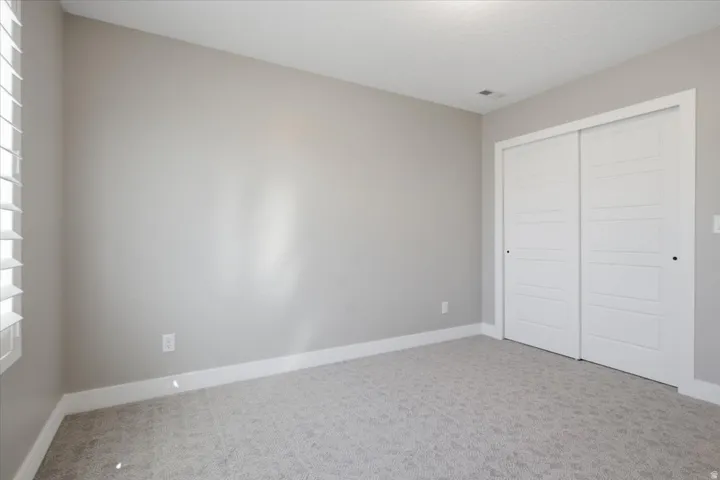 Neutral wall tones, plantation shutters, and sliding closet doors