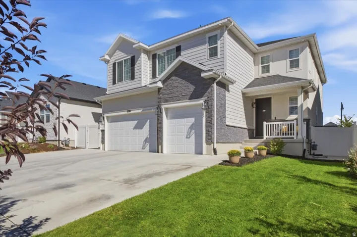 Two-story residence featuring light gray siding and dark gray stone cladding
