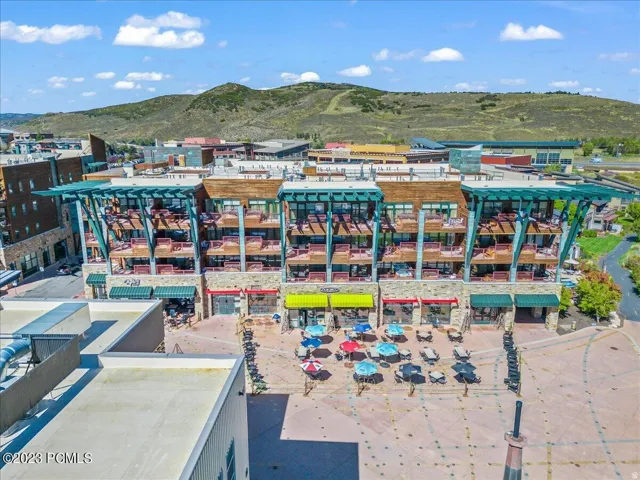 Multi-story building featuring lower-level retail spaces with awnings and upper-level residences with balconies