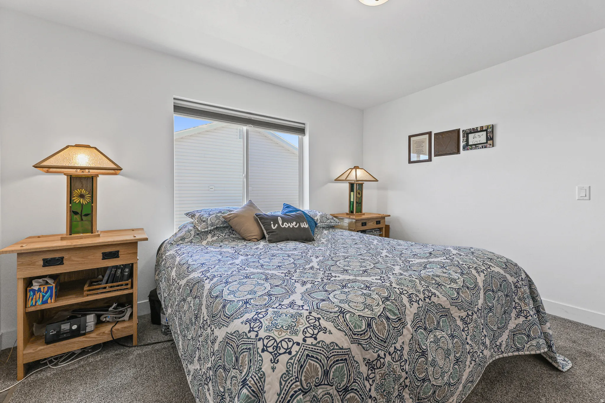 Recessed window with blinds, light-toned walls, and carpet flooring
