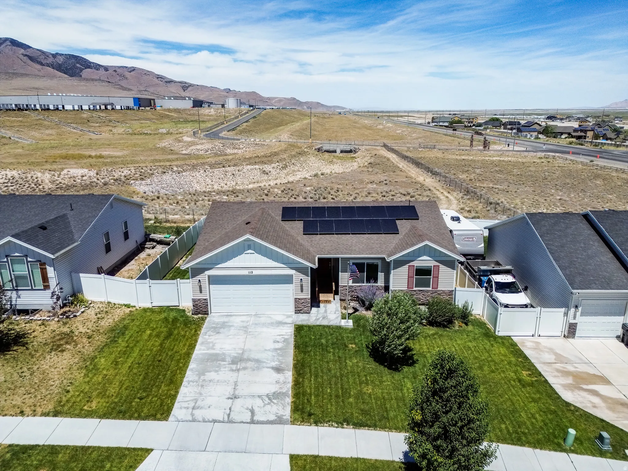 Single-story residence featuring solar panels, an attached two-car garage, and a concrete driveway