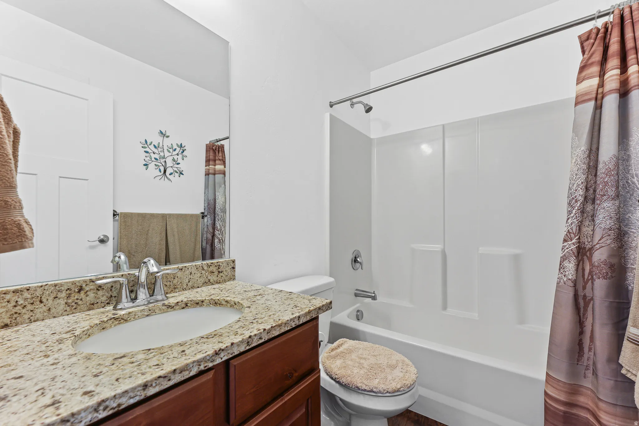 Vanity with a granite countertop, undermount sink, and chrome faucet
