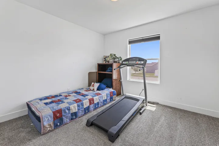 Carpeted room with a single window and white walls