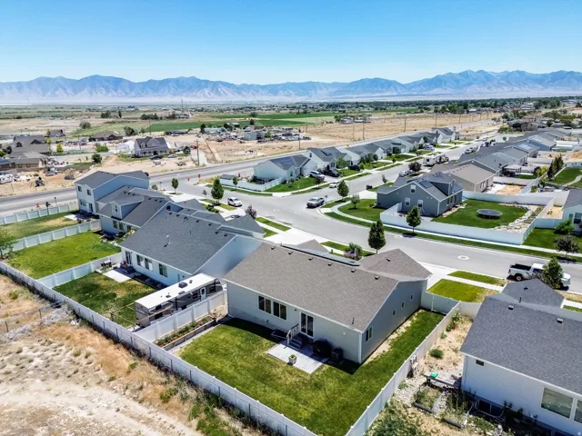 Residential neighborhood with mountain backdrop, paved streets, and fenced properties
