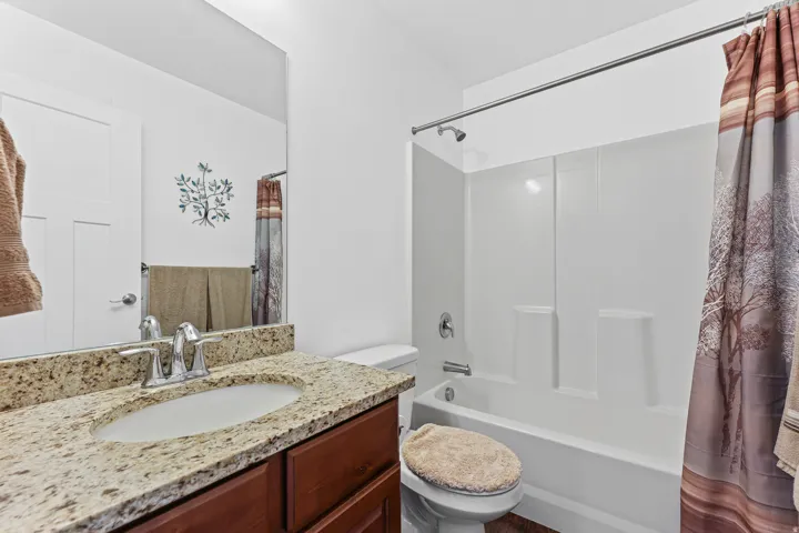 Vanity with a granite countertop, undermount sink, and chrome faucet