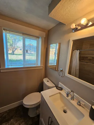 Vanity with integrated sink, chrome faucet, and framed mirror