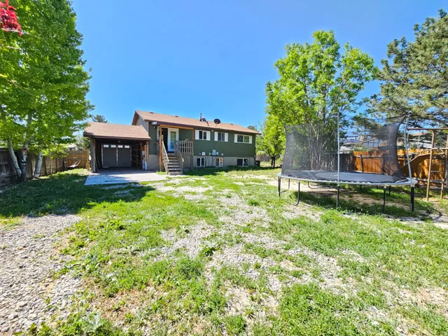 Rear exterior featuring a covered carport, attached garage, and multi-level deck access