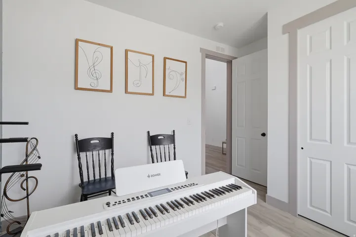 Light-toned flooring, white walls, and white paneled doors with dark hardware