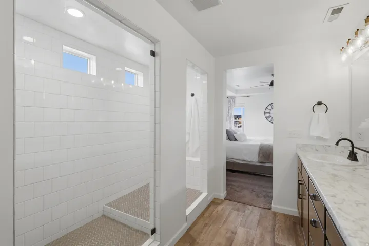 Walk-in shower with subway tile surround and herringbone pattern floor