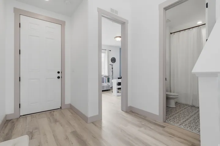 Wood-finish flooring throughout, white paneled doors, and grey trim accents