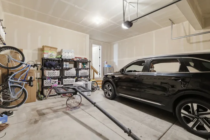 Concrete flooring, overhead lighting, and an automatic garage door opener