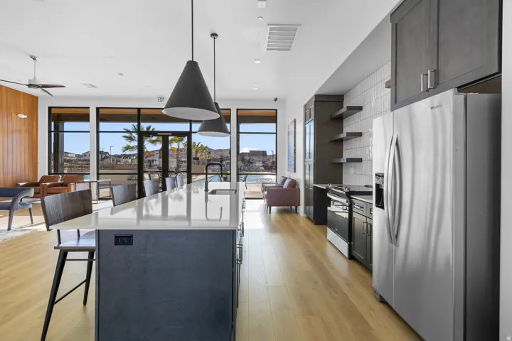 Spacious kitchen island with a light-toned countertop, integrated sink, and black matte faucet