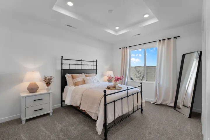 Recessed lighting, tray ceiling, carpeted flooring, and a large window
