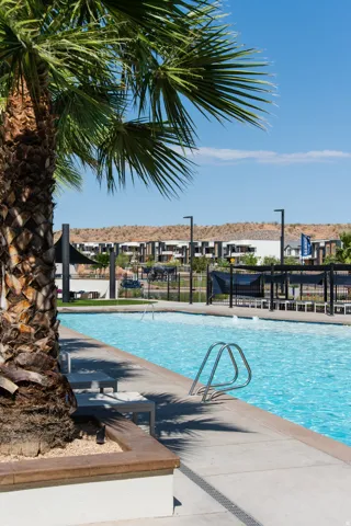 Swimming pool with concrete decking, a metal handrail, and integrated water features