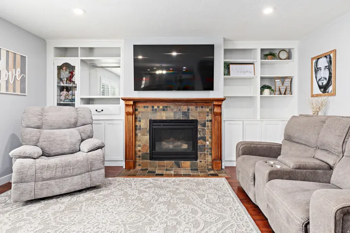 Built-in shelving flanking a fireplace with a wood mantel and tile surround