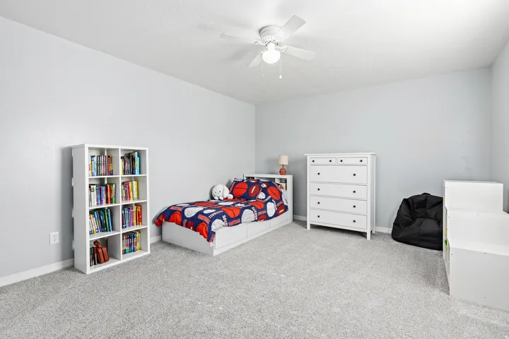 Light gray wall color, textured ceiling, ceiling fan with integrated lighting, and light gray carpeting