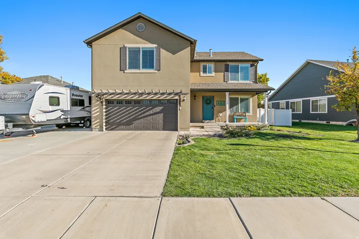 Two-story stucco exterior with a covered porch, attached two-car garage, and a concrete driveway