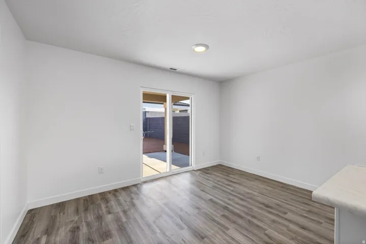 Wood-finish flooring, white walls, and a sliding glass door providing access to an outdoor area