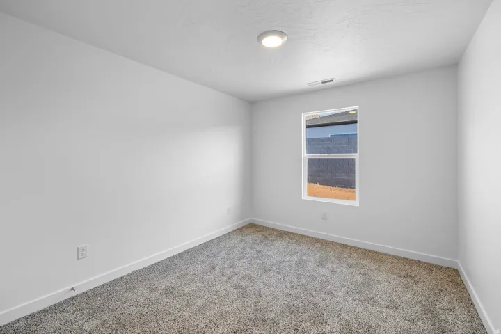 Recessed ceiling light, neutral wall paint, white trim, and gray carpet